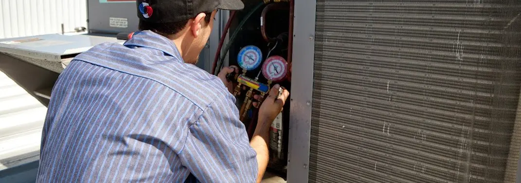 HVAC technician servicing a condenser unit in Rushville