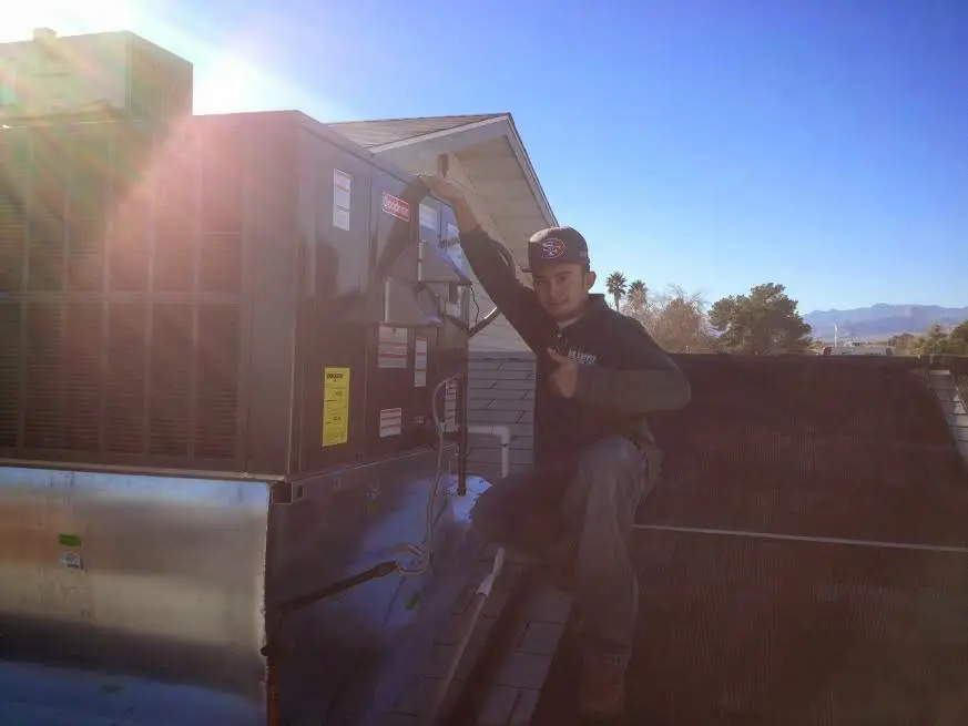 HVAC technician performing Heat Pump Repair on a rooftop unit in Rushville
